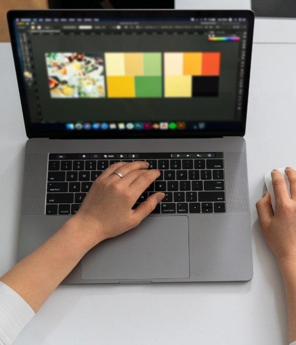 Woman designing and preparing print-ready files using design software on a laptop